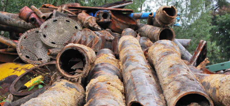 Berg aus gestapelten rostigen Eisenrohren, Gullideckeln und Hydranten zur Entrümpelung in Hamburg-Eimsbüttel